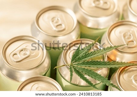 A collection of aluminum cans with a cannabis leaf. Trending concept of CBD-infused beverages with hemp. Eco-friendly packaging and wellness industry.