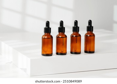 Collection of Amber Glass Dropper Bottles Displayed on a Minimalist White Surface in Natural Light - Powered by Shutterstock