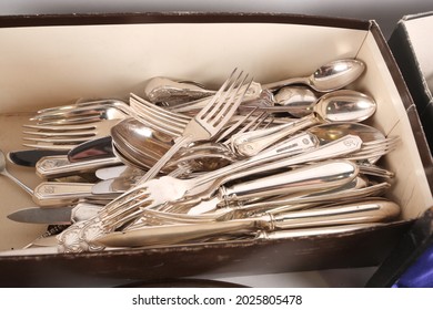 A collection of antique silver flatware. The cutlery may include Spoons, Forks and knives. Photographed on a white background.