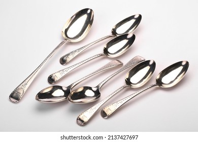A collection of antique silver flatware. Photographed on a light background.