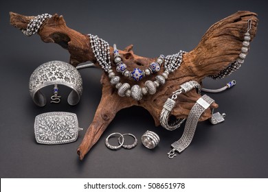 Collection of antique traditional silver jewelry on old wood and black paper