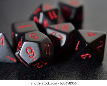 A collection of black gaming dice used for tabletop gaming
