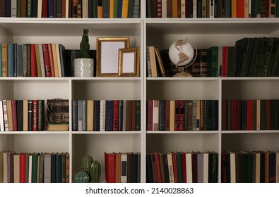 Collection of books and decor elements on shelves. Home library - Powered by Shutterstock