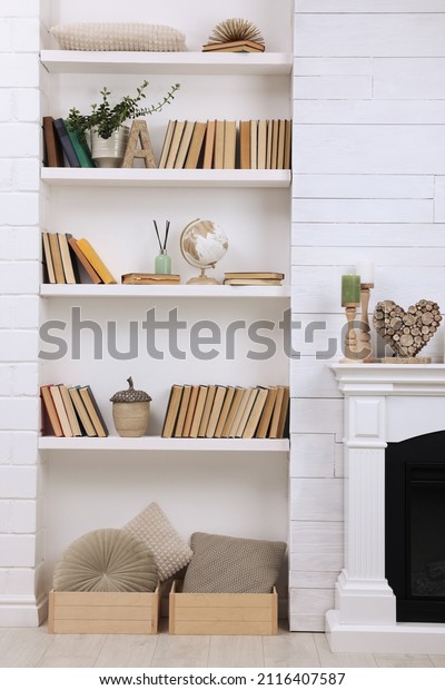 Collection of books and decor elements on shelves\
indoors. Interior\
design
