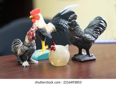 Collection Of Chicken Figurines On Top Of A Desk