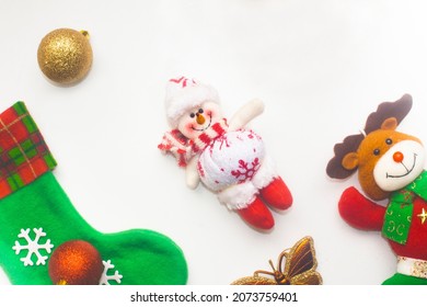 Collection of Christmas decorations with white background, snowman, Christmas boot, golden butterfly, reindeer and golden ball, top view

