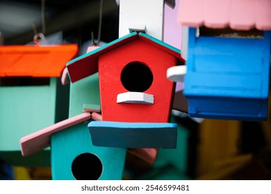 A collection of colorful birdhouses hanging in a vibrant display, perfect for enhancing gardens, patios, or outdoor spaces with a charming and artistic touch. - Powered by Shutterstock