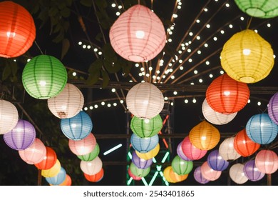 collection of colorful paper lanterns hanging from above, illuminated against a dark night sky.  - Powered by Shutterstock