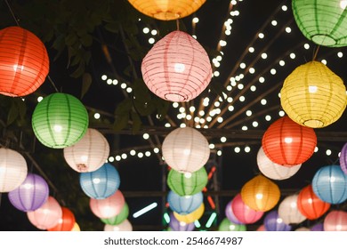 collection of colorful paper lanterns hanging from above, illuminated against a dark night sky.  - Powered by Shutterstock