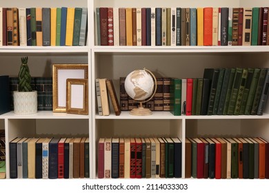 Collection of different books and decorative elements on shelves in home library - Powered by Shutterstock