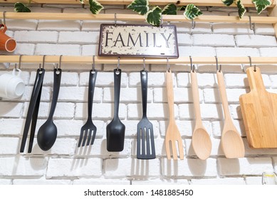 A collection of different ceramics,wooden complement a patterned tiles kitchen behind white brick wall.Kitchenware and tree hanging on the wall. Modern kitchen at home 