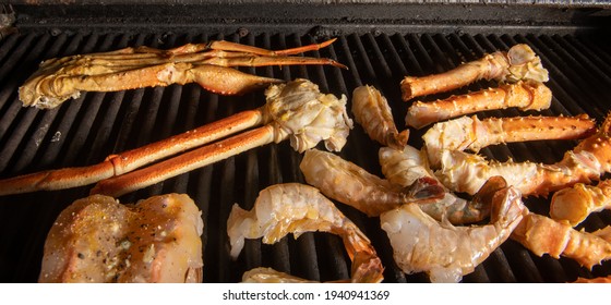 A Collection Of Different Kinds Of Seafood Bbq Cooking On A Grill With  Tiger Shrimp, Alaskan Snow Crab And Alaskan King Crab