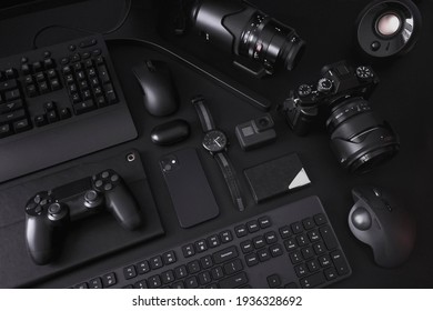 A collection of electronic gadgets all in black organized in a minimalist style. - Shutterstock ID 1936328692