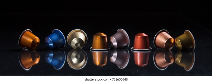 Collection of espresso coffee capsules isolated on black background, Closeup view with details, banner