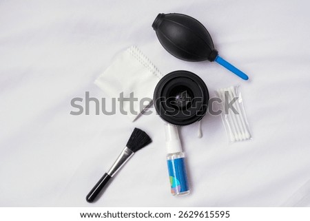 A collection of essential camera cleaning tools, featuring an air blower, lens cleaning cloth, and brush, ideal for maintaining camera equipment and ensuring clear photography results.