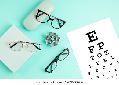 Collection of eyeglasses with eye test table. Optical store, glasses selection, eye test, vision examination at optician, fashion accessories concept. Top view, flat lay - Powered by Shutterstock