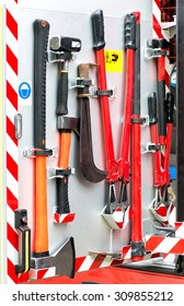 Collection Of Fire Fighting Tools And Equipment Neatly Mounted On A Metal Panel On A Fire Engine Or Fire Fighter's Vehicle Ready For Emergency Use