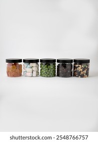Collection of five transparent jars with different fillings of the same size on a white background. High quality photo
