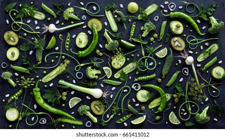 Collection of fresh green fruit and vegetables on the black wooden table, top view - Powered by Shutterstock