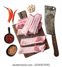 A collection of fresh raw pork ribs sits on a wooden cutting board alongside garlic, red chili peppers, and various spices, ready for cooking and seasoning Isolated on wh Isolated on white background - Powered by Shutterstock