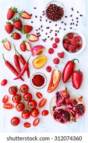 Collection Of Fresh Red Toned Vegetables And Fruits Raw Produce On White Rustic Background, Peppers Capsicum Chilli Strawberry Raspberry Pomegranate Tomato Paprika Azuki Beans Plum