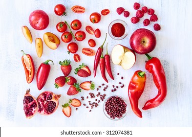 Collection of fresh red toned vegetables and fruits raw produce on white rustic background, peppers capsicum chilli strawberry raspberry pomegranate tomato paprika azuki beans plum - Powered by Shutterstock