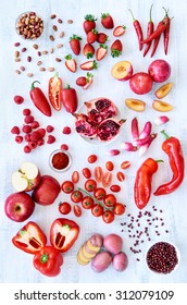 Collection Of Fresh Red Toned Vegetables And Fruits Raw Produce On White Rustic Background, Peppers Capsicum Chilli Strawberry Raspberry Pomegranate Tomato Paprika Azuki Beans Plum