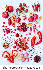 Collection Of Fresh Red Toned Vegetables And Fruits Raw Produce On White Rustic Background, Peppers Capsicum Chilli Strawberry Raspberry Pomegranate Tomato Paprika Azuki Beans Plum