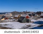 Collection of homes with Hans Egede statue on hilltop by Church of our Saviour in Nuuk in Greenland