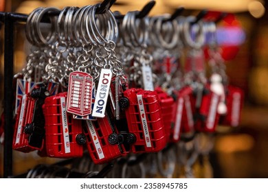 A collection of London souvenir keyrings featuring vintage red buses and telephone boxes on sale at a souvenir shop in central London