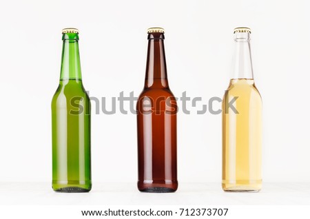 Collection longneck beer bottles 500ml different colors, mock up. Template for advertising, design, branding identity on white wood table.
