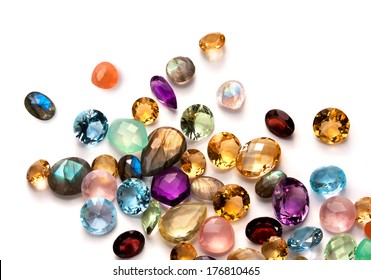 Collection of many different natural gemstones on the white background: amethyst, lapis lazuli, rose quartz, citrine, ruby, amazonite, moonstone, labradorite, chalcedony, blue topaz and many more.