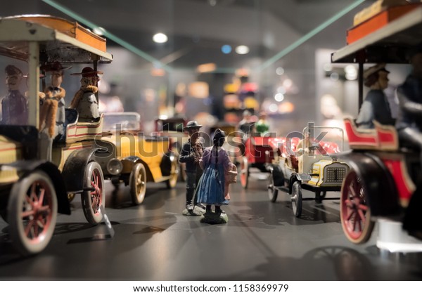 a collection of model cars of early motorized\
vehicles with their drivers