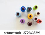 Collection of multi-colored thread spools for sewing and embroidery craft.