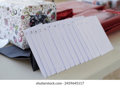A collection of numbered white envelopes which are gifts at an event