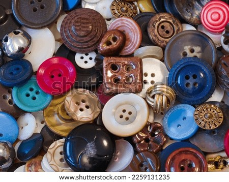 A collection of old buttons accumulated over many years of home sewing. Different kinds of buttons, different colors and shapes. Close up.