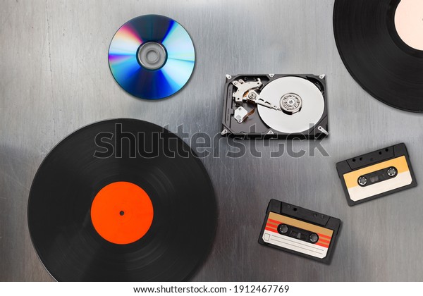 A collection of old and modern\
storage devices, record videocassette, audiocassette,\
disk