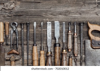 Collection of old woodworking and carving tools on a rough vintage table: carpentry, craftsmanship and handwork concept, flat lay