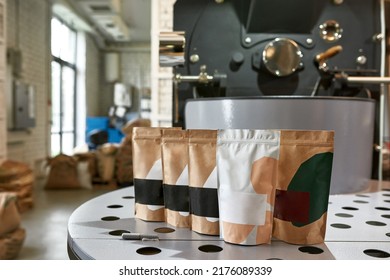 Collection Of Packages With Variety Coffee On Coffee Bean Roasting Machine On Factory. Coffee Making And Production. Small Business. Modern Automated Equipment. Natural Ecological Manufacturing