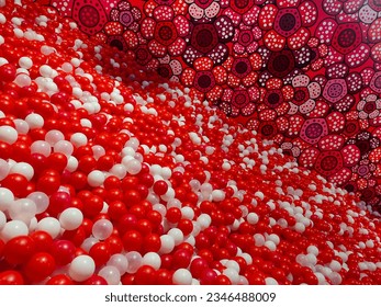 a collection of red and white balls with red patterned walls looks unique and abstract