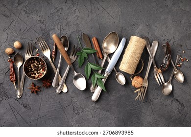 A collection of rustic kitchen flat-lay compositions featuring vintage silverware, assorted spices, herbs, coarse salt, peppercorns, dried chili and wooden utensils.