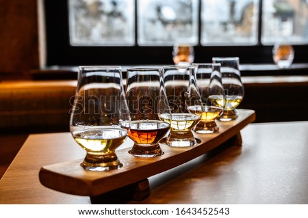 Collection of Scottish whisky, tasting glasses with variety of single malts or blended whiskey spirits on distillery tour in Scotland, UK