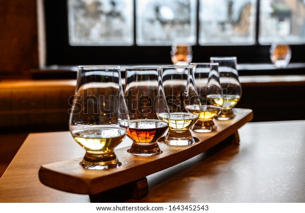 Collection of Scottish whisky, tasting glasses with\
variety of single malts or blended whiskey spirits on distillery\
tour in Scotland, UK