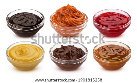 Collection of sweet sauces and syrup, fruit jams, chocolate and caramel creams isolated on white background with clipping path