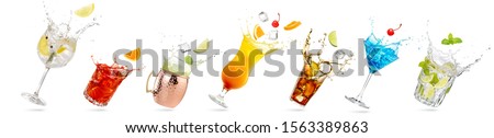 collection of tilted glasses with splashing cocktails isolated on white