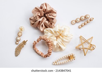 Collection of trendy silk elastic band scrunchies and pearl hair clips on white background. Diy accessories and hairstyles concept, luxury color - Shutterstock ID 2143847041