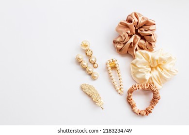 Collection of trendy silk elastic band scrunchies and pearl hair clips on white background. Diy accessories and hairstyles concept, luxury color - Shutterstock ID 2183234749
