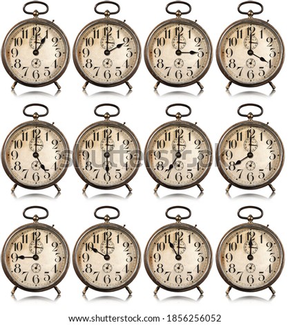 Collection of twelve old alarm clocks with all hours of the day, isolated on white background, photography.