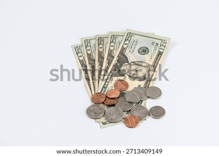 A collection of US dollars and assorted coins laid on a clean white surface. Perfect for topics like money, finance, savings, budgeting, and payments in everyday life.