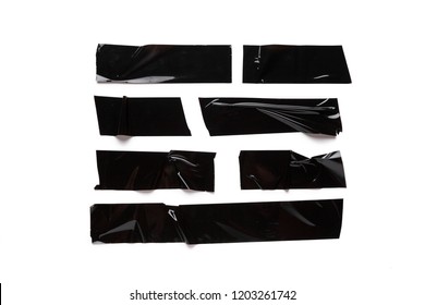 A collection of used black electrical tape pieces isolated on white background